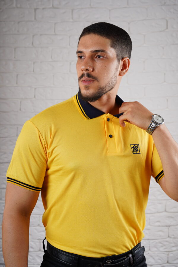 Camiseta Polo BB na cor Amarelo Ouro com símbolo bordado na cor Azul Marinho com friso na gola e punho de cor Azul Marinho - Imagem 3