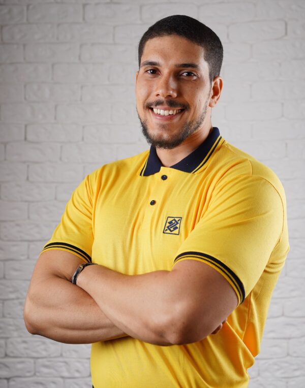 Camiseta Polo BB na cor Amarelo Ouro com símbolo bordado na cor Azul Marinho com friso na gola e punho de cor Azul Marinho